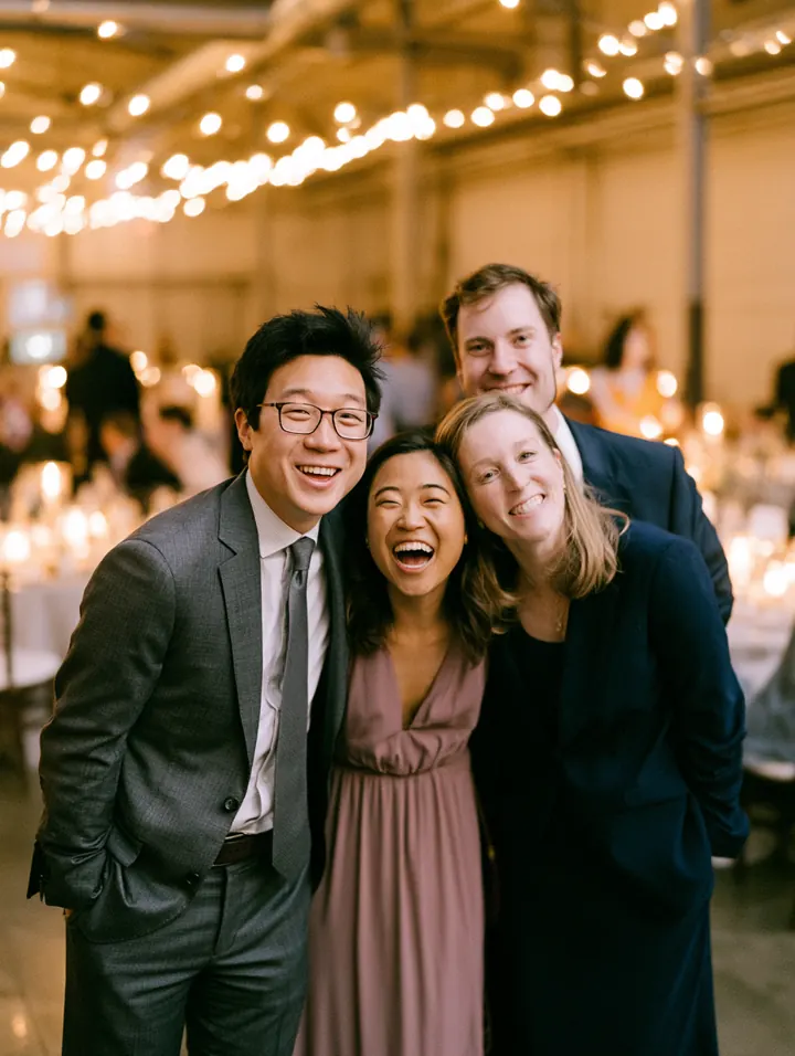 Four guests smiling at a candlelit reception